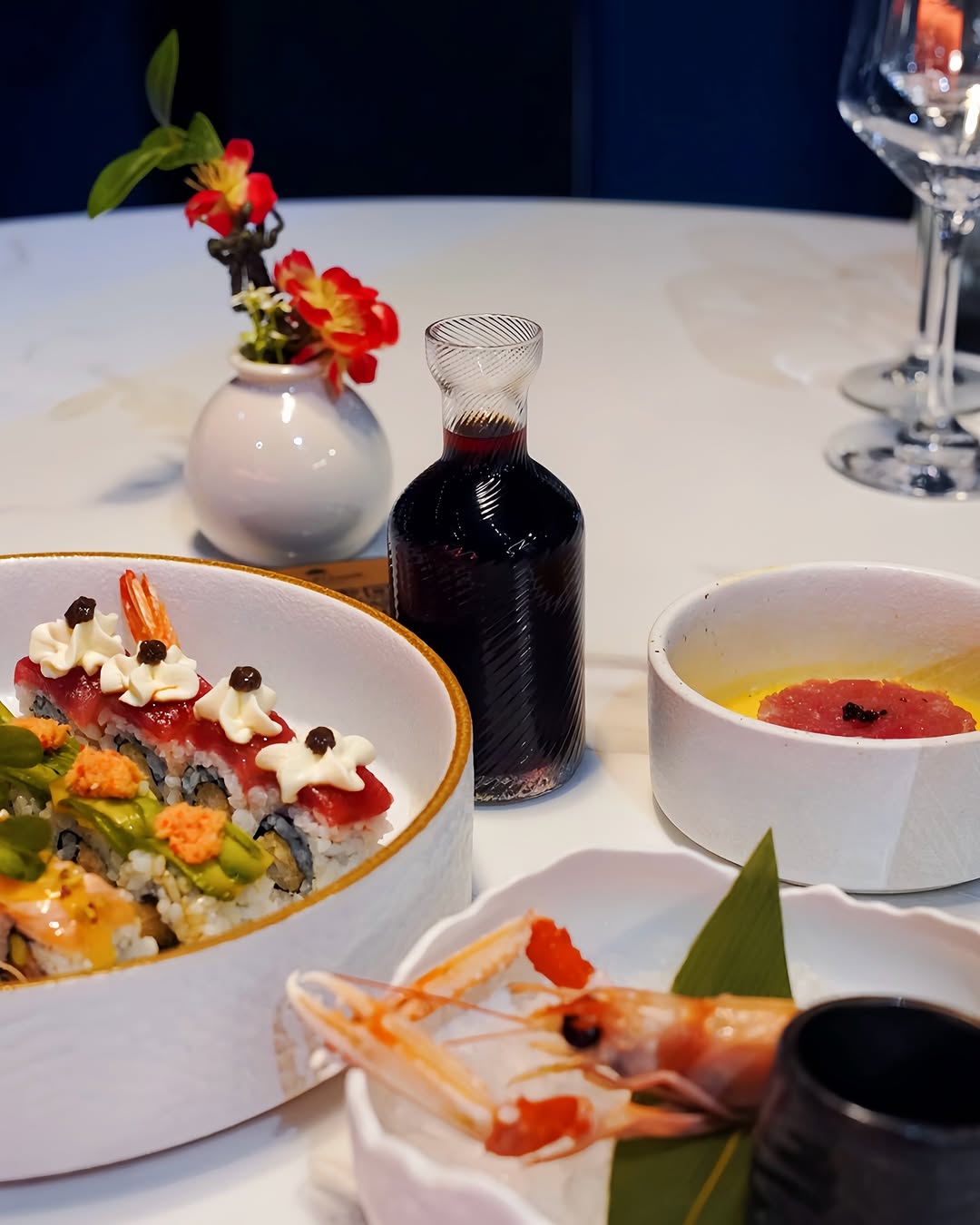Tavola di uramaki, tartare di tonno e scampi crudi